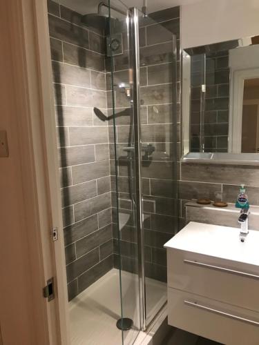 a glass shower in a bathroom with a sink at Stunning pied-a-terre moments from the water. in Netley