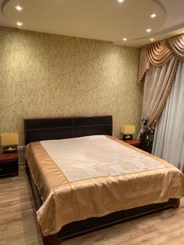 a bedroom with a large bed and two side tables at Приватний будинок з сауною та більярдом in Khashchevoye