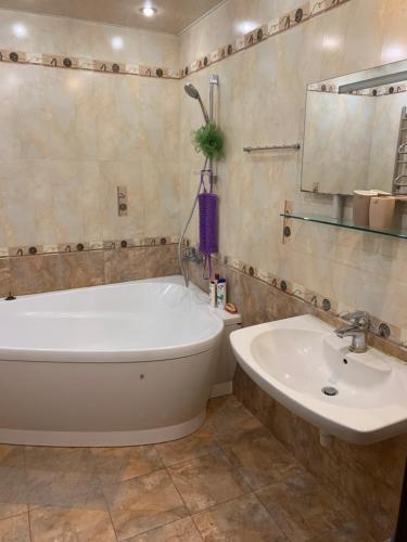 a bathroom with a tub and a sink at Приватний будинок з сауною та більярдом in Khashchevoye