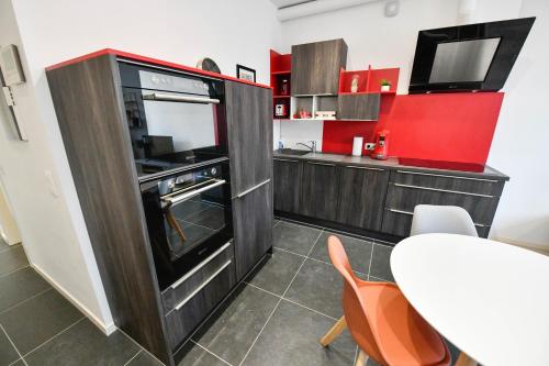 a small kitchen with a table and a tv at Les Cerisiers - Appartement Cosy au Centre de Namur in Namur