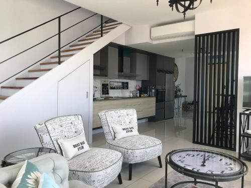 a living room with two chairs and a table at SUNRISE Gurney Seaview Luxury Duplex in George Town