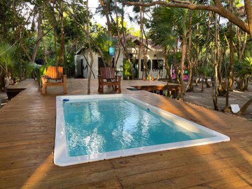 una grande piscina su una terrazza in legno con alberi di Sol y Arena Xcalak a Xcalak