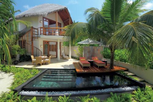 a villa with a swimming pool and a house at Constance Halaveli in Hangnaameedhoo