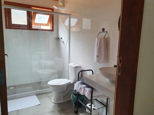 een badkamer met een toilet, een wastafel en een douche bij Loft Pé na Serra in Cachoeiras de Macacu