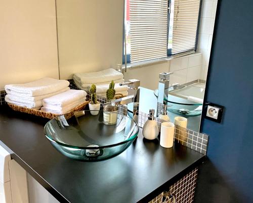a bathroom with a glass sink and a mirror at LE CARDINAL, appartement avec parking privé, gare, centre ville, in Annecy