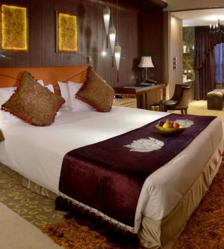 a bedroom with a large bed with a bowl of fruit on it at Radisson Blu Hotel MBD Ludhiana in Ludhiana