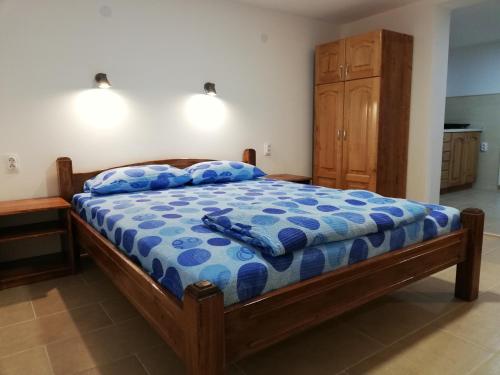 een slaapkamer met een bed met een blauw dekbed bij Sobe i apartmani Simic in Ribarska Banja
