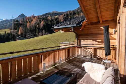 a balcony of a wooden house with a swimming pool at Chalet-Appartement mit Penthouse Flair in Bad Hofgastein