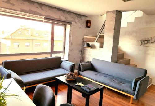 a living room with a couch and a table at TOLETUM low cost LOFTS diáfanos o 2dormitorios PARKING Municipal Gratis al aire libre a 100m in Toledo