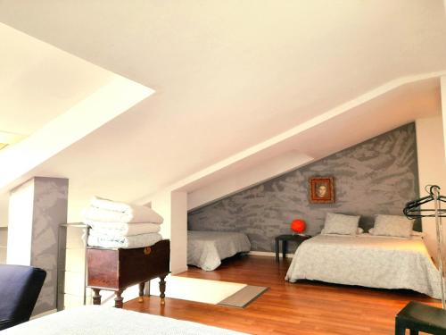 a bedroom with two beds and a stone wall at TOLETUM low cost LOFTS diáfanos o 2dormitorios PARKING Municipal Gratis al aire libre a 100m in Toledo