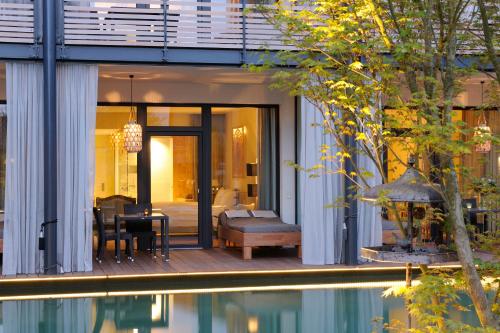 a house with a pool in front of it at Wellnessgarten-Hotel in Waging am See