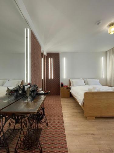 a bedroom with two beds and a table in it at ConnectIN Apartments in Pale
