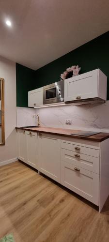 a kitchen with a counter top with a microwave at Apartamenty Pastelowe, Suntago, Deepspot, Mszczonów in Mszczonów