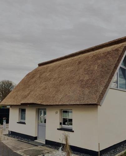a white cottage with a thatched roof at Haus Findling in Zingst