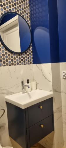 a bathroom with a sink and a mirror at Apartamenty Pastelowe, Suntago, Deepspot, Mszczonów in Mszczonów