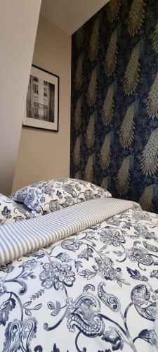 a bedroom with a bed with a blue and white blanket at Apartamenty Pastelowe, Suntago, Deepspot, Mszczonów in Mszczonów