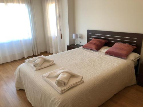sypialnia z dużym białym łóżkiem z ręcznikami w obiekcie Apartamento en Alcora (Castellón) w mieście Alcora