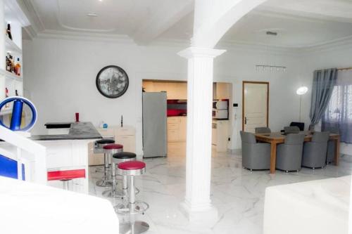 a kitchen and living room with a table and stools at Villa luxueuse - Odza - Yaoundé in Yaoundé
