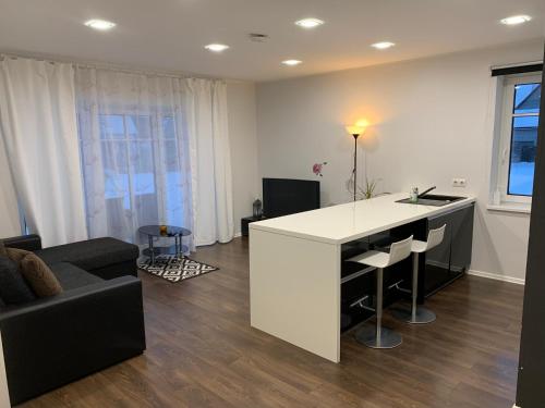 a kitchen and living room with a white counter and a couch at Pärnu Lubja Apartments in Pärnu