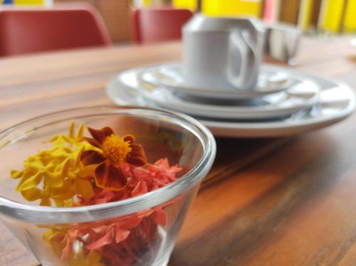 Pousada Céu Azul في ساو ميجيل دو غوستوسو: صحن زجاجي فيه ورد على طاولة