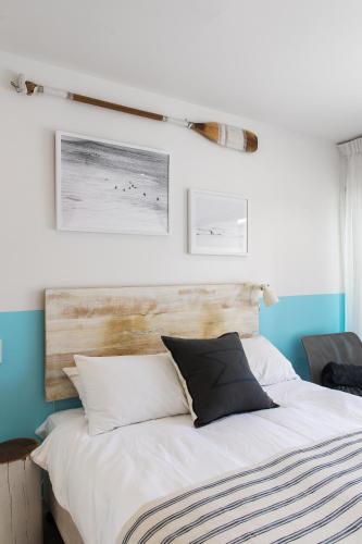 a bedroom with a white bed with a wooden headboard at 10 Hastings Street Motel in Noosa Heads