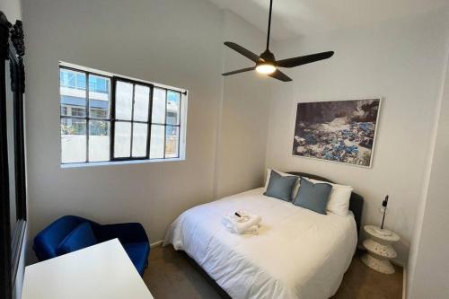 a bedroom with a bed with a ceiling fan at Modern 2 Bedroom Warehouse Conversion in Sydney