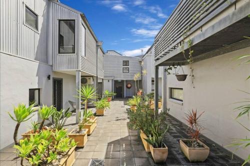 a courtyard of a house with potted plants at Modern 2 Bedroom Warehouse Conversion in Sydney