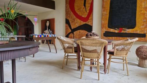 une salle à manger avec des tables, des chaises et un mur dans l'établissement Atelier Sylvio cavalheiro, à Abraão