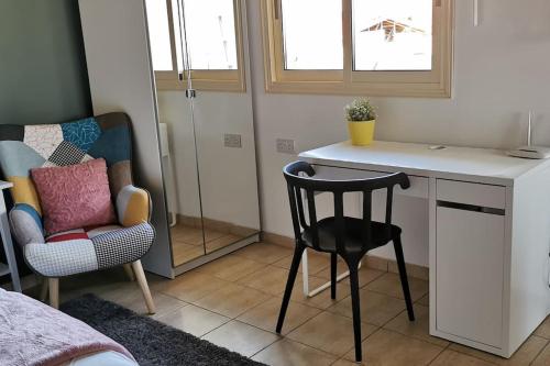 a small room with a desk and a chair and a table at Pretty and quiet studio, with wifi and parking in Limassol