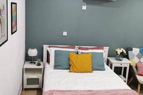 a bedroom with a bed with colorful pillows at Pretty and quiet studio, with wifi and parking in Limassol