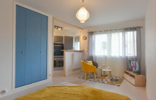 Cet appartement comprend une chambre avec une porte coulissante bleue et une cuisine. dans l'établissement SUPERBE STUDIO PLEIN CENTRE AVEC PARKING PRIVE, à Brive-la-Gaillarde