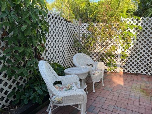 a white couch sitting next to a wooden fence at The Garden House in Key West