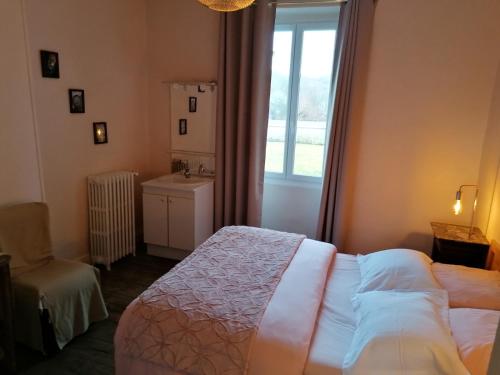 a bedroom with a bed and a window and a sink at Les Ramandes Appartements au cœur du village in Marcillac-la-Croisille