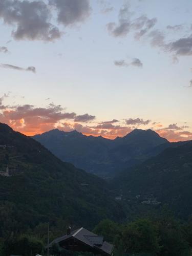 a view of the mountains with the sunset in the background at Chalet Ruitor, chalet 500 m2 luxueux de caractère in Sainte-Foy-Tarentaise