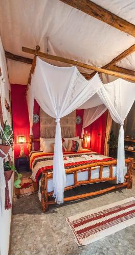 a bedroom with a bed with a canopy at Pousada Quinta da Lagoa Azul in Jijoca de Jericoacoara