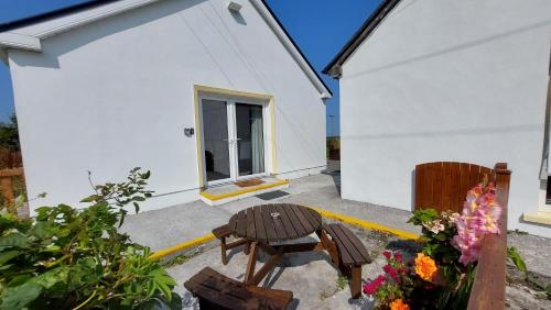 a white house with a table and a bench at Kilronan Holiday Homes in Kilronan