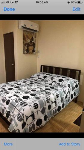1 cama con edredón blanco y negro en un dormitorio en FRANK CRIB, en Cagayan de Oro