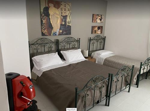a bedroom with two beds and a red suitcase at B&B Al Cavaliere in Lorica