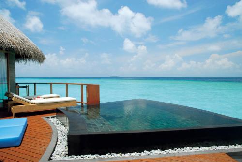 a swimming pool on a deck next to the ocean at Constance Halaveli in Hangnaameedhoo