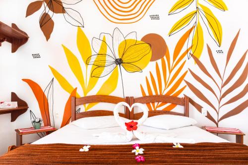 a bedroom with a bed with a flower mural on the wall at Cumbuco Kite in Paradise e Hospedaria in Cumbuco