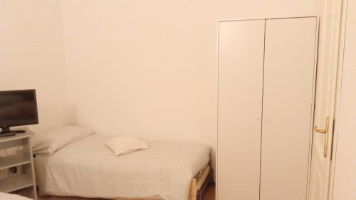 Un pequeño dormitorio con una cama y un televisor. en Verde e mare, en La Spezia