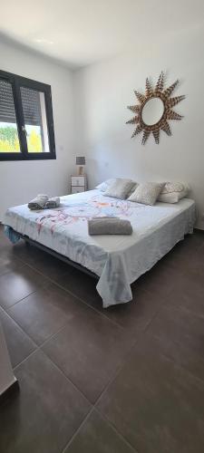 une chambre avec un grand lit avec un miroir au mur dans l'établissement Villa Cosy avec piscine privative, à Ghisonaccia