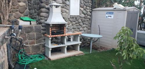 a garden with a bird house and a table at kinneret love sounds in Migdal