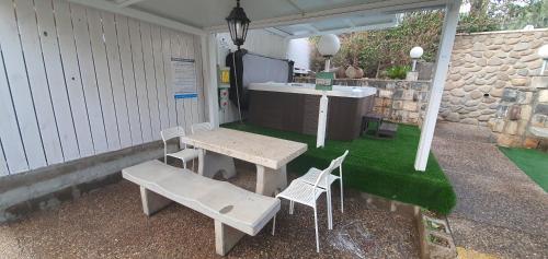 a patio with a table and chairs and a bench at kinneret love sounds in Migdal