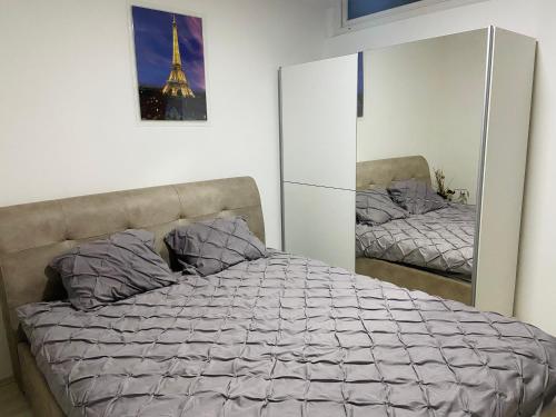 クマノヴォにあるGOLD LUXURY APARTMENTのベッドルーム1室(鏡付きのベッド1台、エッフェル塔付)