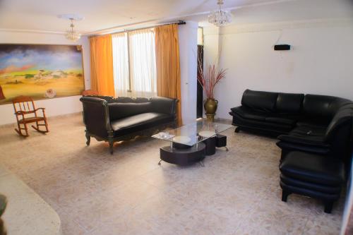 a living room with black leather furniture and a table at Hotel La Makuira RB in Ríohacha