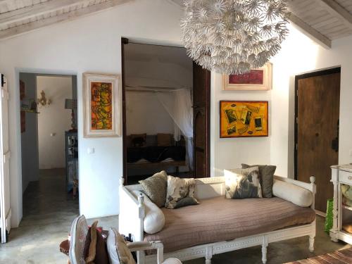 salon z kanapą i żyrandolem w obiekcie Monte dos Binos w mieście Porto Covo