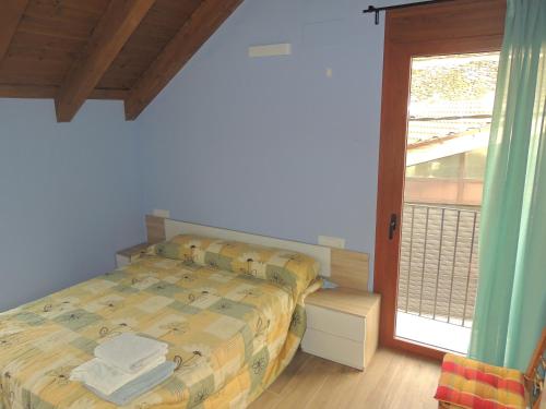 a bedroom with a bed and a large window at Casa Rural Sardas - Sabiñanigo in Sabiñánigo