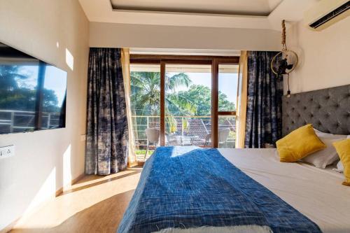a bedroom with a bed and a large window at Casa Amore Luxury 3 Bedroom Villa in Assagao North Goa in Vagator