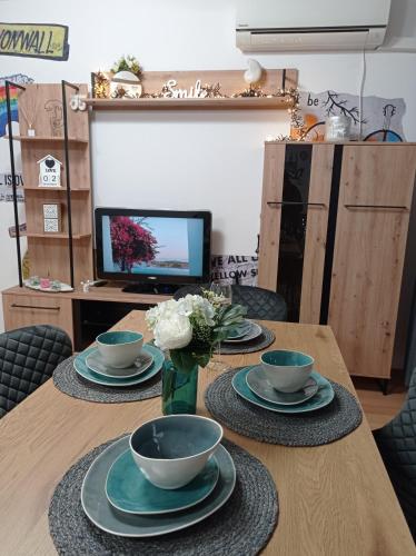 uma mesa com pratos e tigelas e um vaso de flores em Prague Suite em Burgas